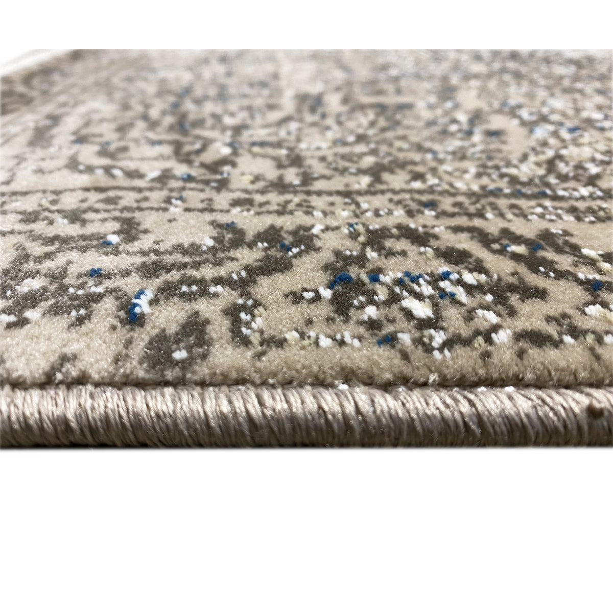 Teppichflor in Beige mit dunklem Muster und blauen Farbakzenten am Rand