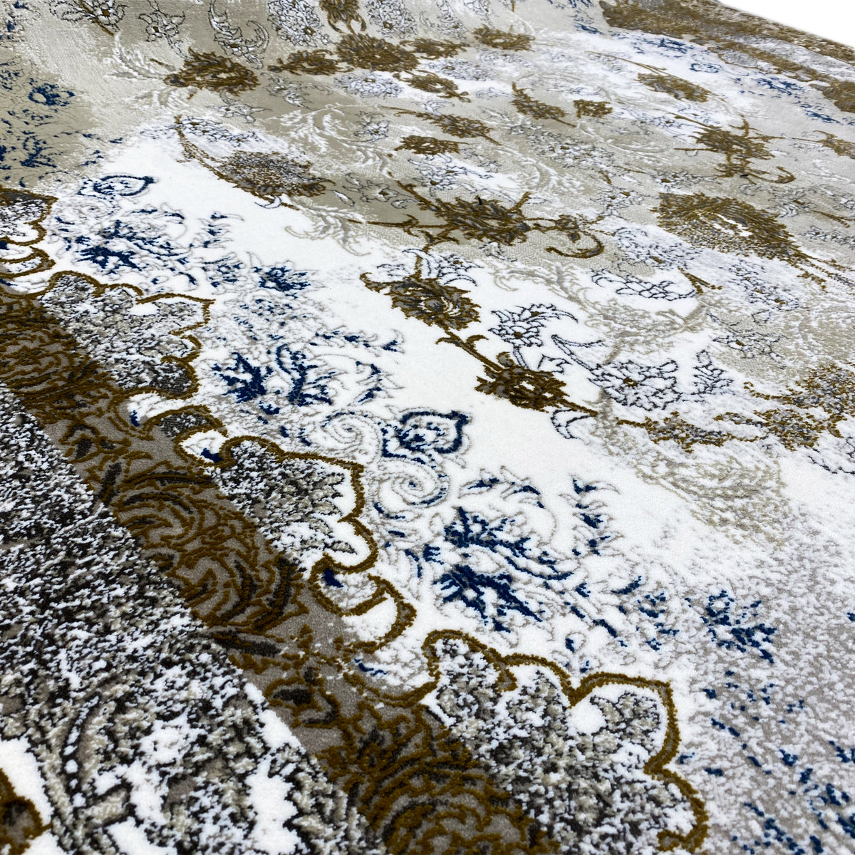Detailansicht: beiges Ornamentmuster in Goldbraun und Blau auf Teppichoberfläche