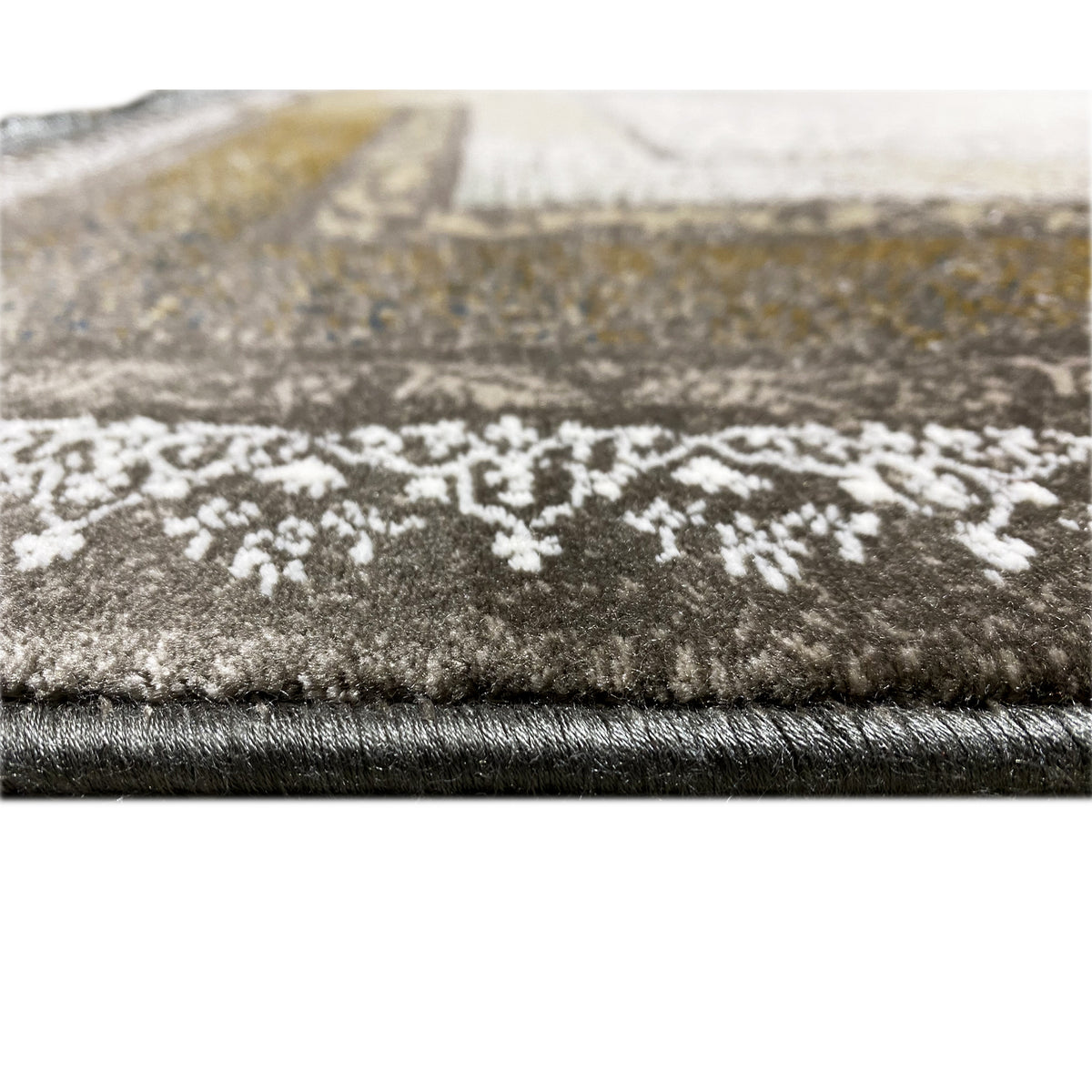 Teppichsaum im Detail mit kurzen Fransen und dichtem Flor, gemustert in Hell und Dunkelbraun/Gold