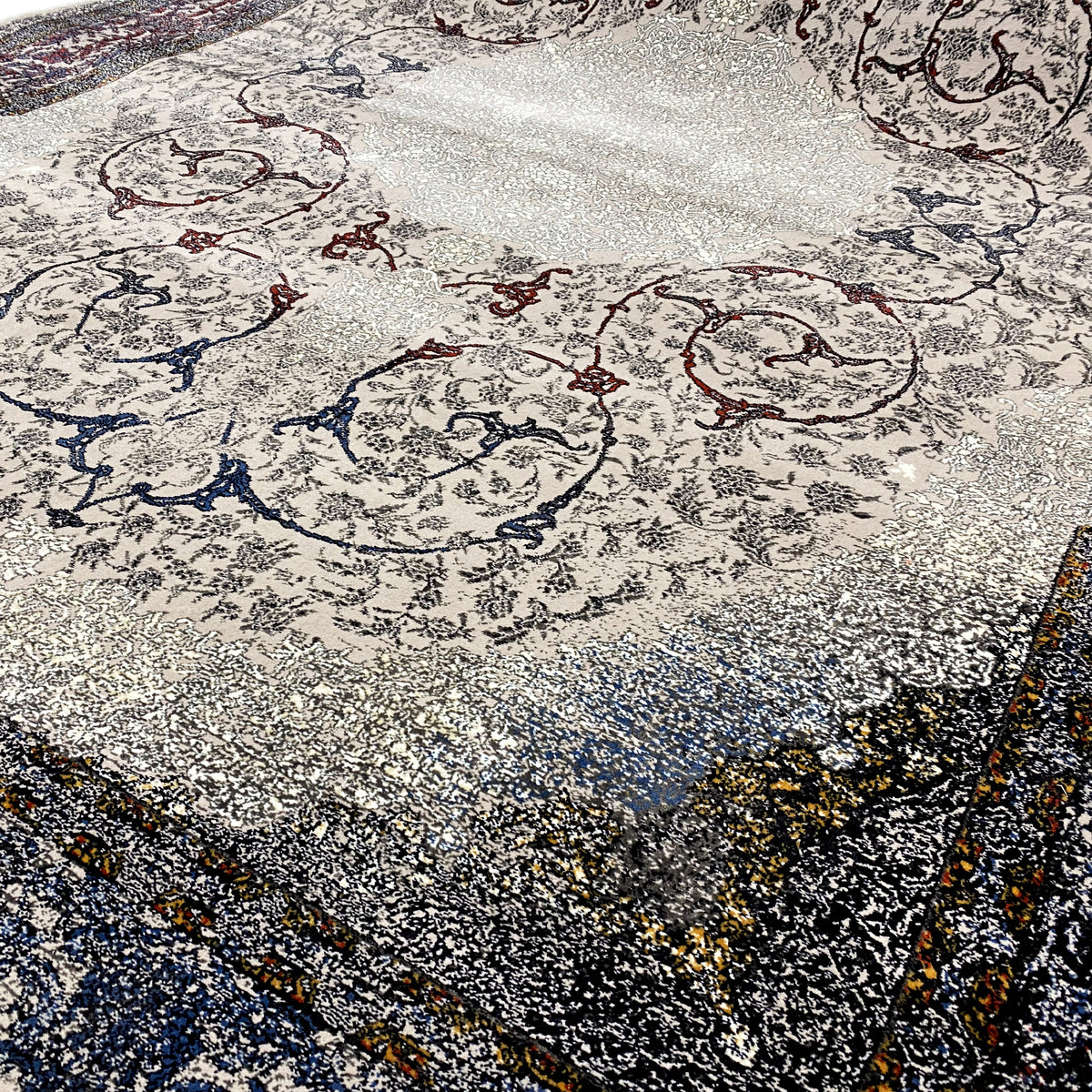 Teppichfläche mit dekorativen Ornamenten in Grau, Dunkelblau und Akzenten in Gelb