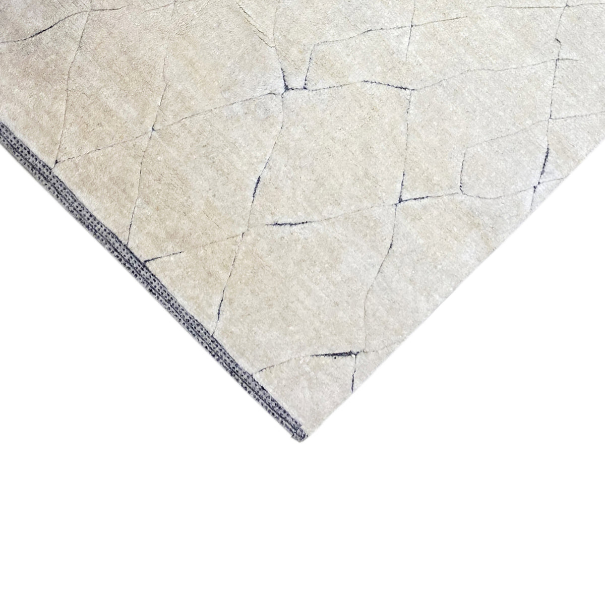 Eckansicht des Creme-Teppichs mit blauer Rahmenkante und geometrischen Linien