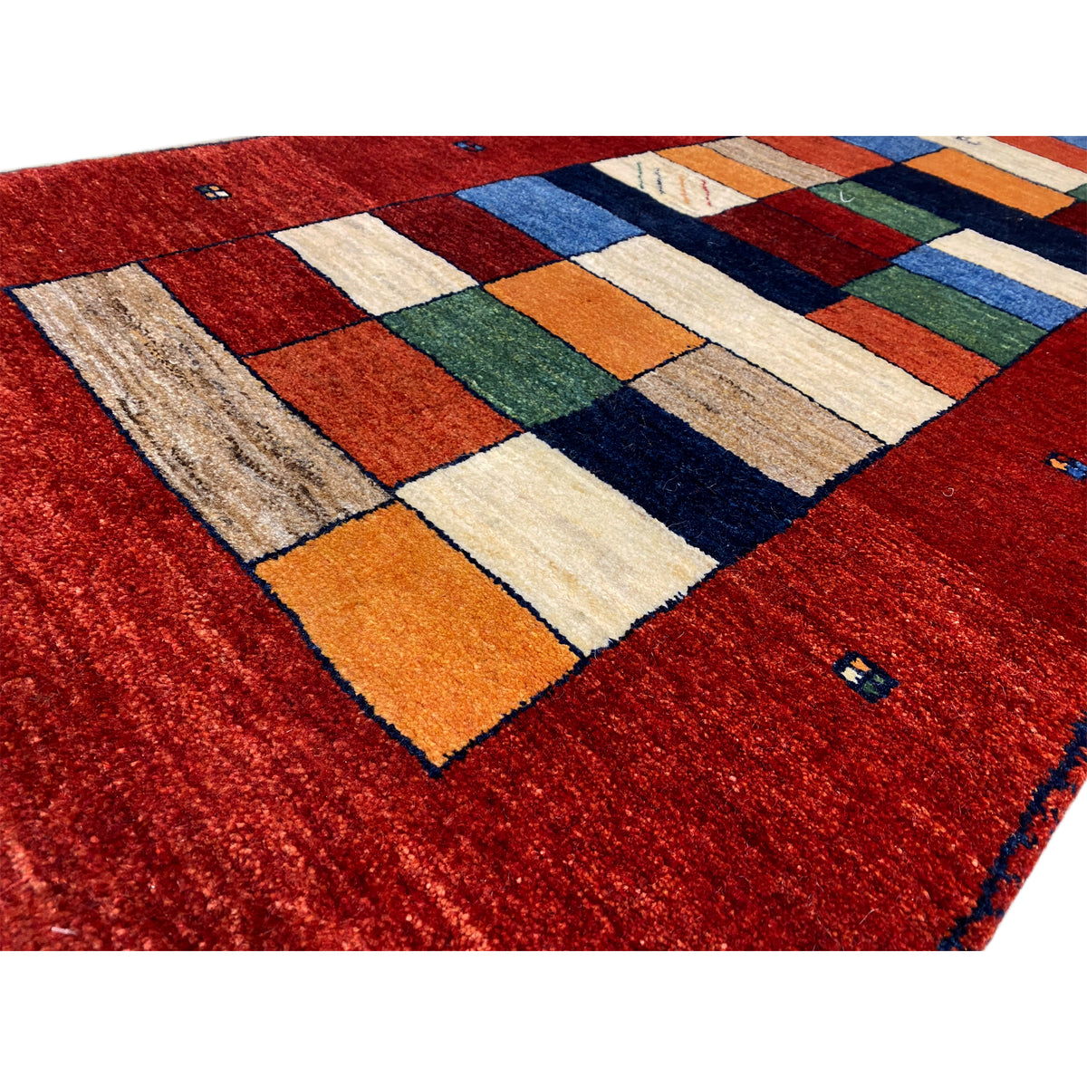 Gabbeh-Teppichläufer Detail: rote Fläche mit buntem Quadratmuster und Noppenrand