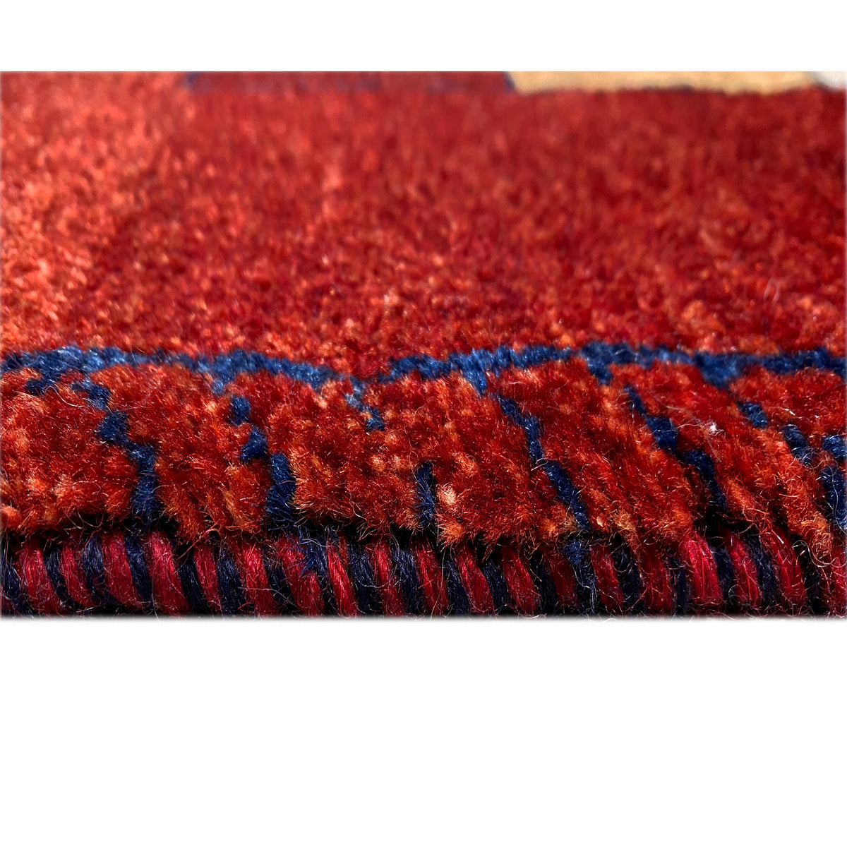 Roter Gabbeh-Teppich-Läufer mit Fransen und blauem Besatz am Rand.