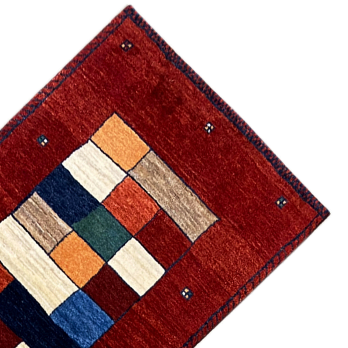 Eckdetail: roter Gabbeh-Teppichläufer mit zentralem Quadratmuster und blauer Umrandung