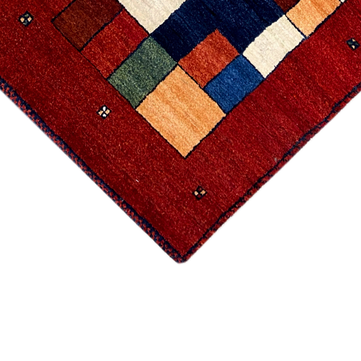 Eckansicht des roten Teppichläufers mit zentralem geometrischem Muster und Bordüre.