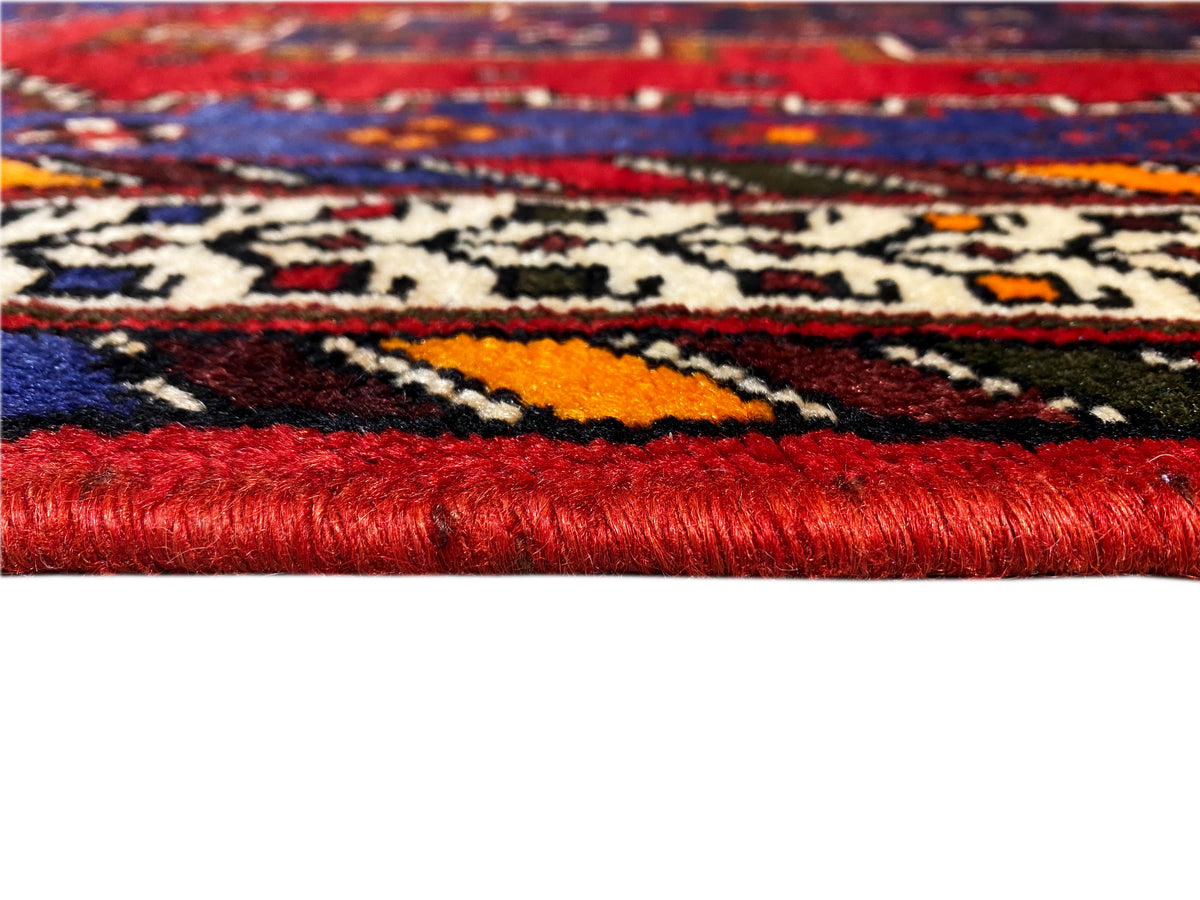 Sirjan-Läuferteppich: Detail mit rotem Flor, farbigem Muster und gewebtem Rand