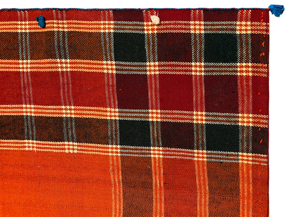 Detail des Jajim Teppichs: kräftiges Rot-Orange Karo mit schwarzen Flächen und weißen Linien