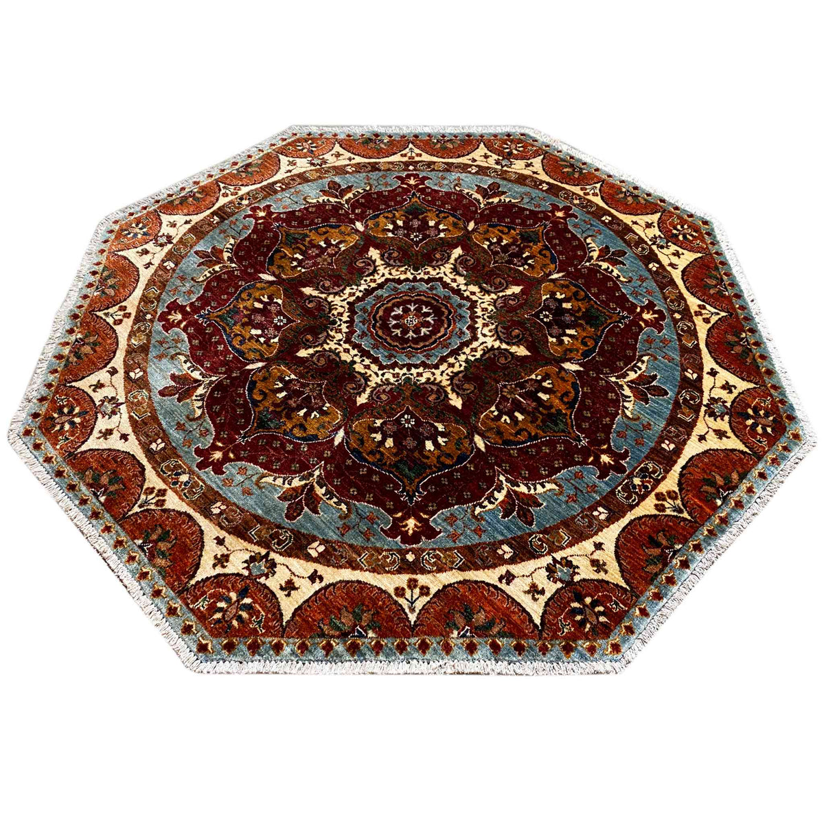 Achteckiger Teppich mit rundem Ornamentmedaillon, Blau- und Rottönen, cremefarbener Umrandung.