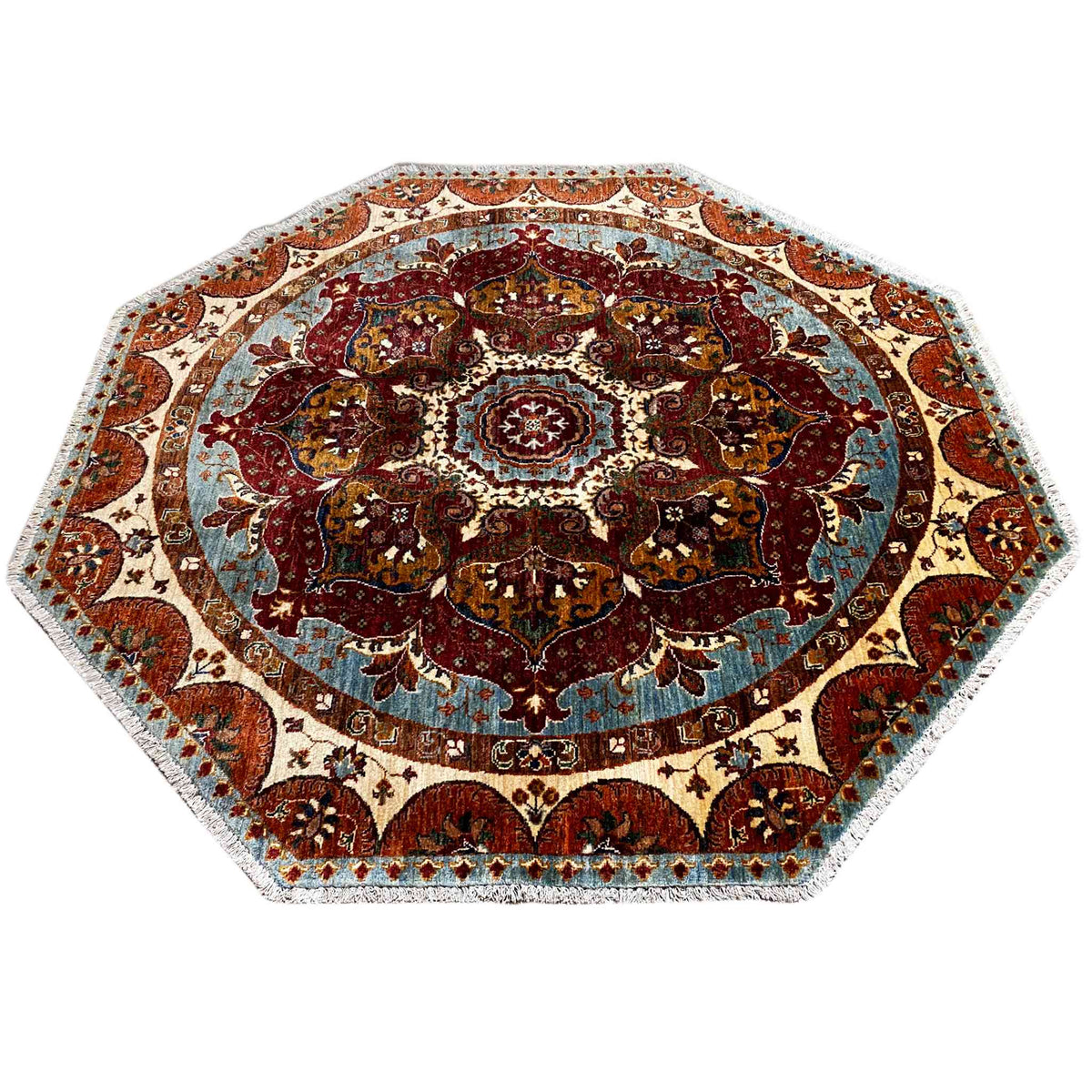 Achteckiger Teppich mit dichtem Paisley-Ornament und zentraler Rosette, rot, blau und beige.