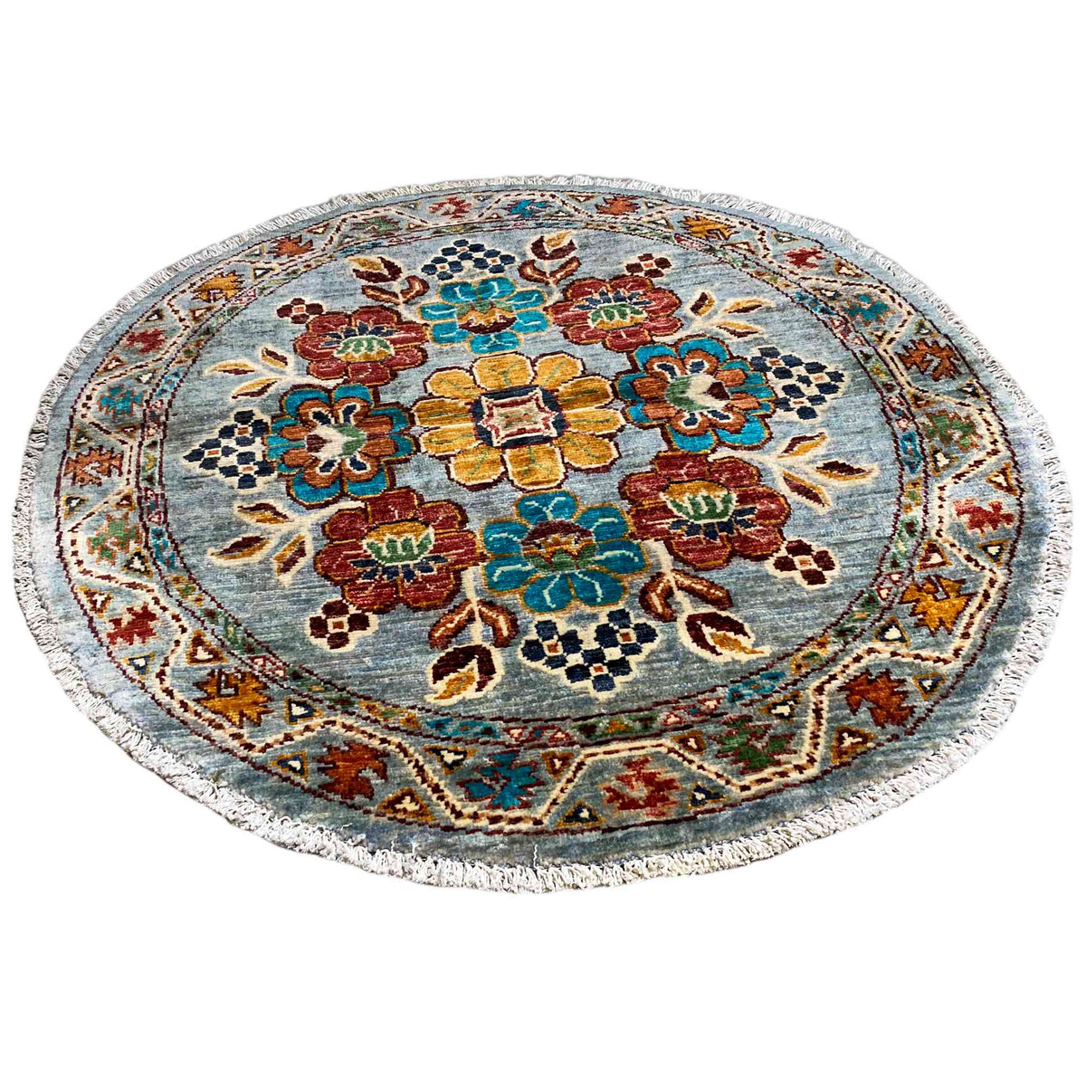 Runder Wollteppich mit blauem Untergrund und bunten Blumenornamenten
