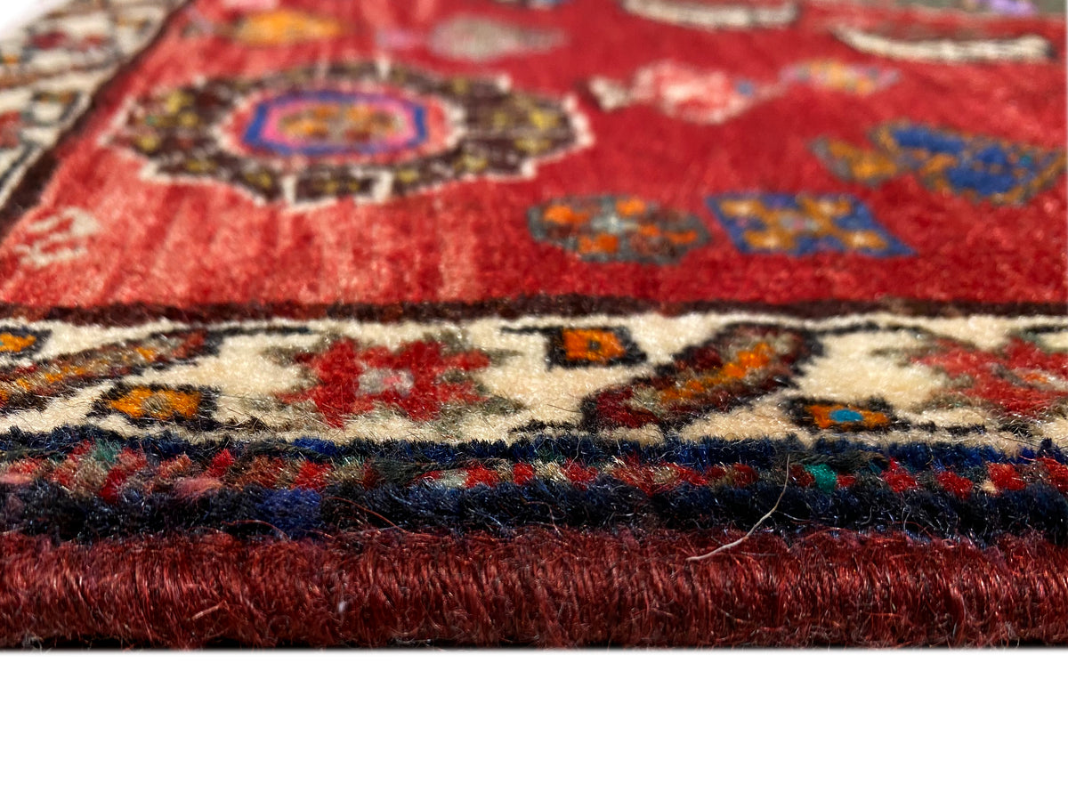 Detail Poshti-Teppich 58x57 cm: roter Flor, farbige Musterkante und kurzer Fransenbesatz