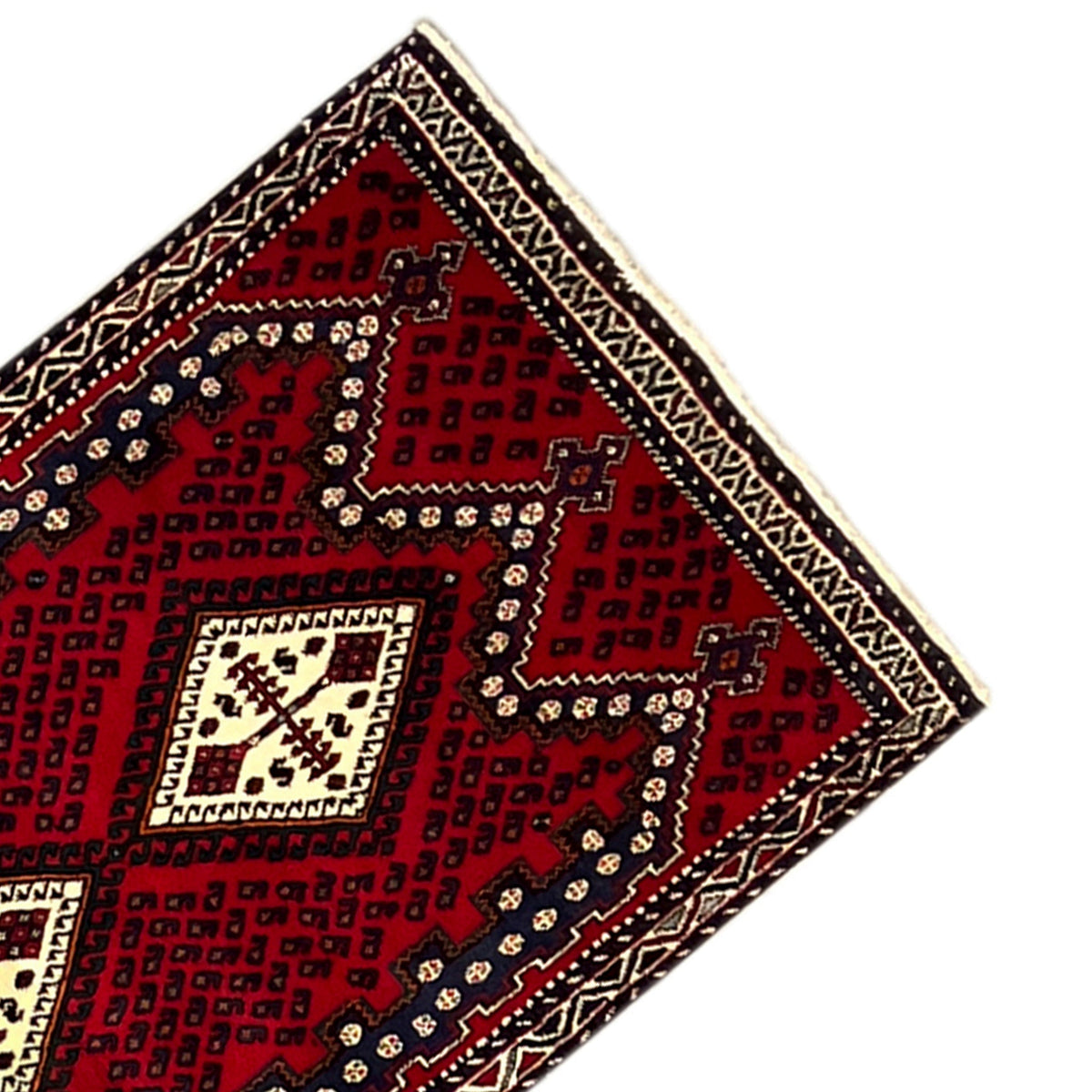 Eckansicht: roter Teppich mit geometrischem Ornament in Dunkelblau und Creme