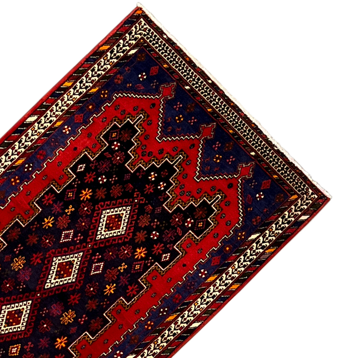 Teppichläufer-Ecke mit roter Innenfläche, blauen Akzenten und beigem Bordürenmuster