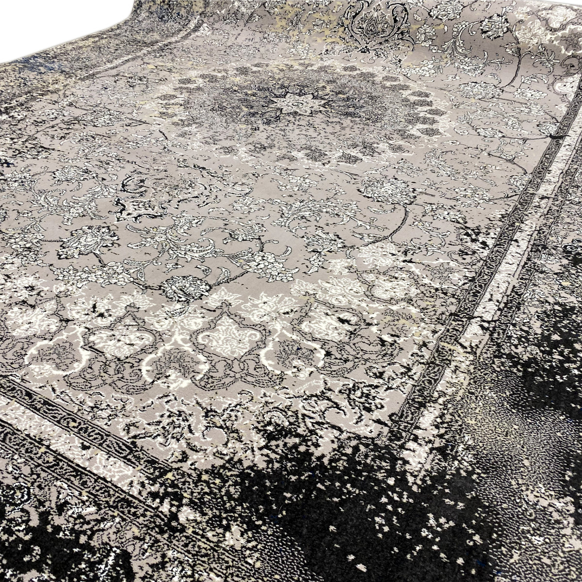 Nahaufnahme: Vintage-Teppich in Grau mit Ornamenten und dunkler gesprenkelter Bordüre
