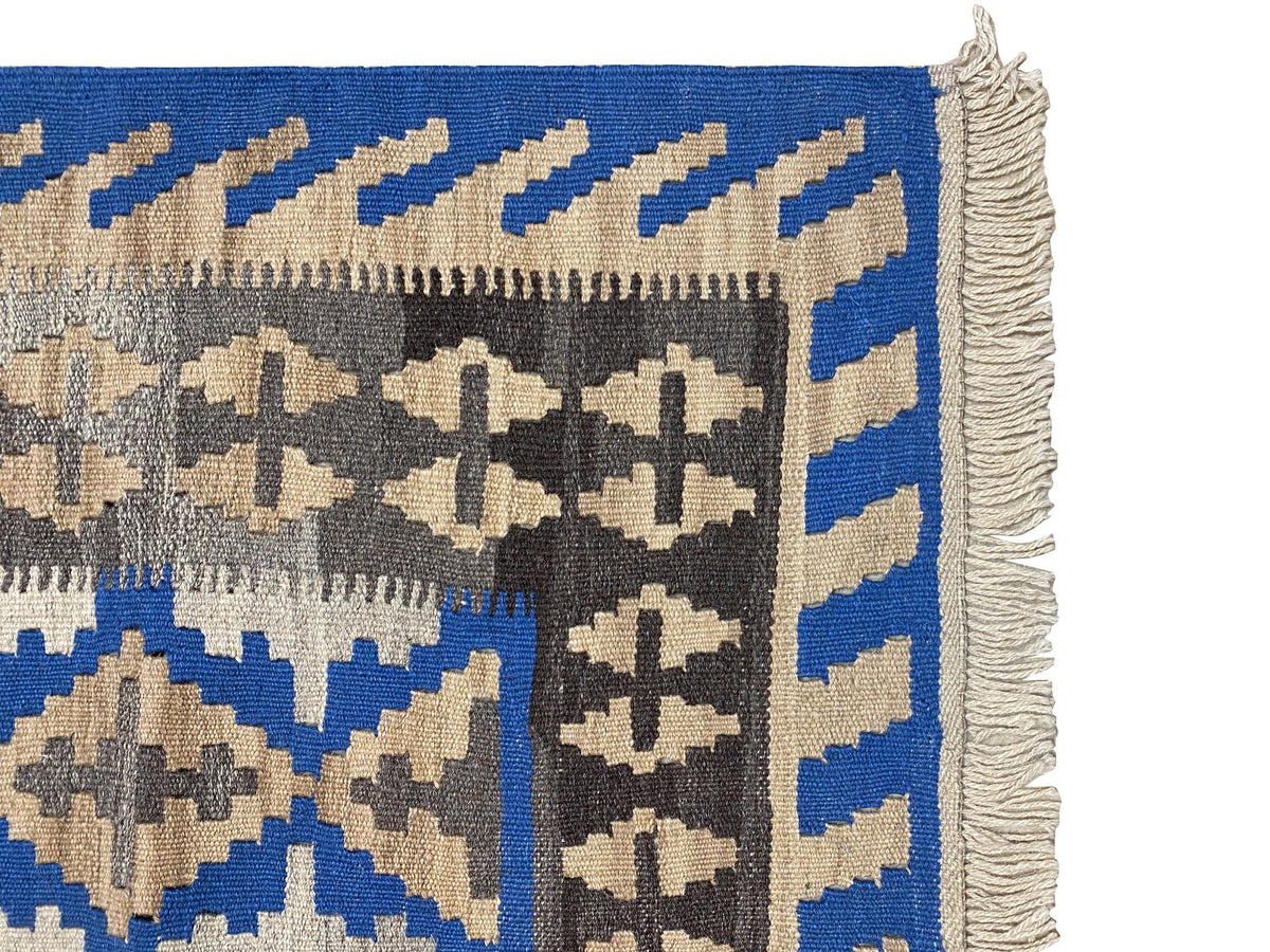 Detailansicht: Kelim-Teppich Rand mit Fransen und blauem Streifenband, beiges Innenmuster