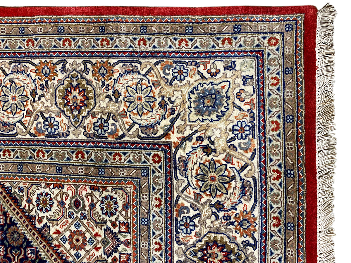 Teppich-Ecke mit Fransen: helles Musterfeld, rote Umrandung und blau-gemusterte Streifen