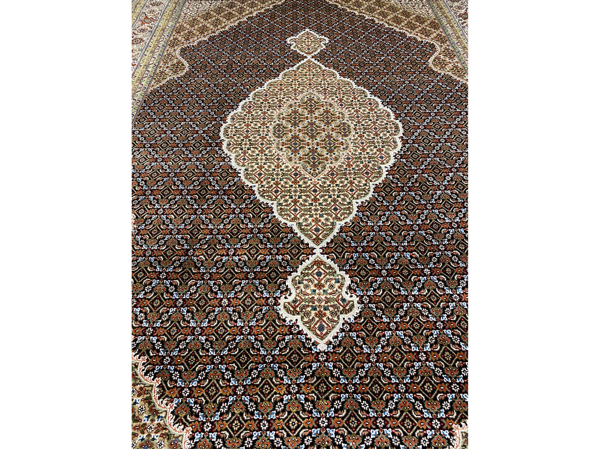 Nahaufnahme des braunen Indo-Tabriz Teppichs: zentrales Medaillon, feine Rauten und Ornamente.