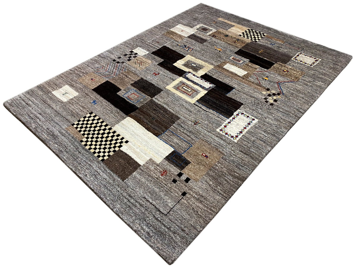 Gabbeh Teppich 235x171 cm, schräg präsentiert: Patchworkmotive in Grau und Dunkelbraun