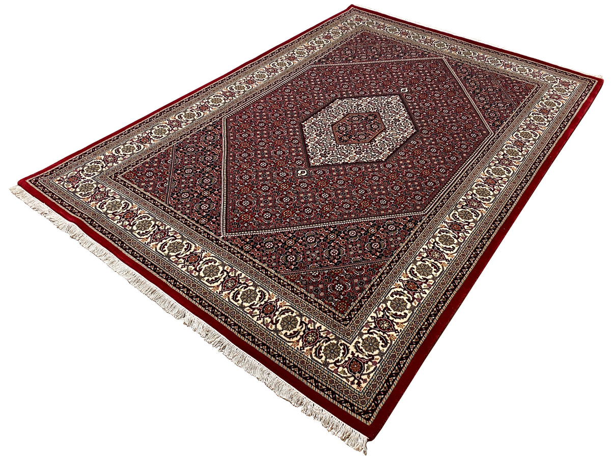 Teppich 244x170 cm schräg gezeigt: rotes Medaillonmuster mit Fransen