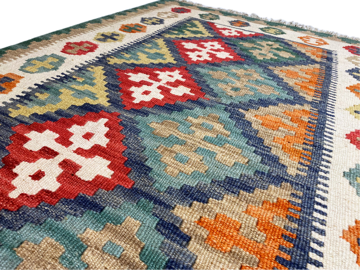 Detailansicht Kelim-Teppich: farbige Rauten, Kantenborte und gefilzte Struktur