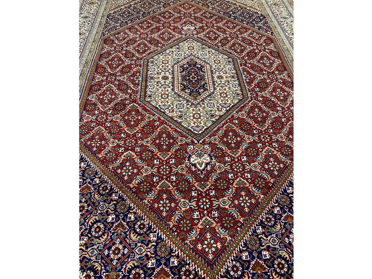Teppich mit rotem Muster und blauem Rahmen, zentrales Medaillon mit Ornamenten