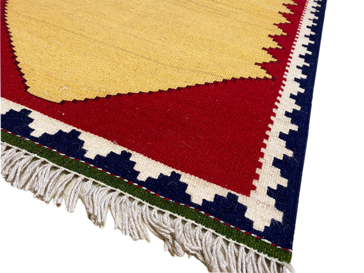 Detail vom Kelim-Teppich: Fransen, rote Querfläche und blau-weiße Randmuster