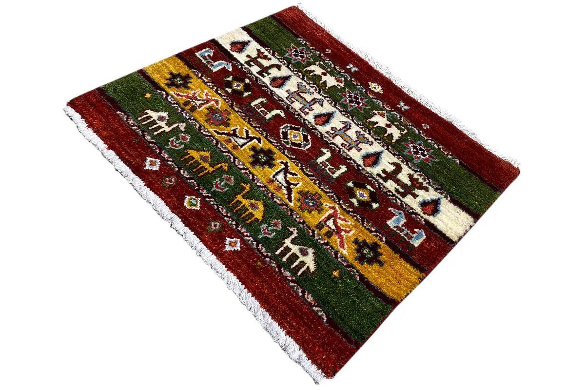 Gabbeh-Lori-Teppich, 55x64 cm: schräg gezeigt, rot-grün-gelbe Streifen mit Figuren