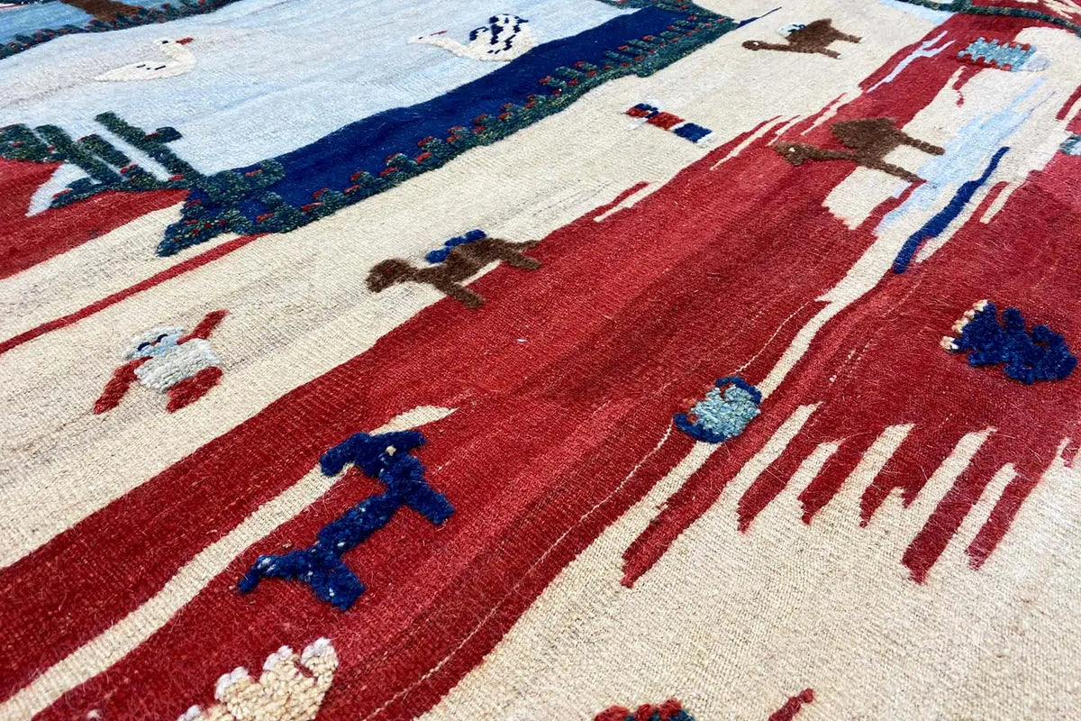 Kilim-Qashqai-Teppich Detailansicht mit roten Flächen und blauen stilisierten Motiven