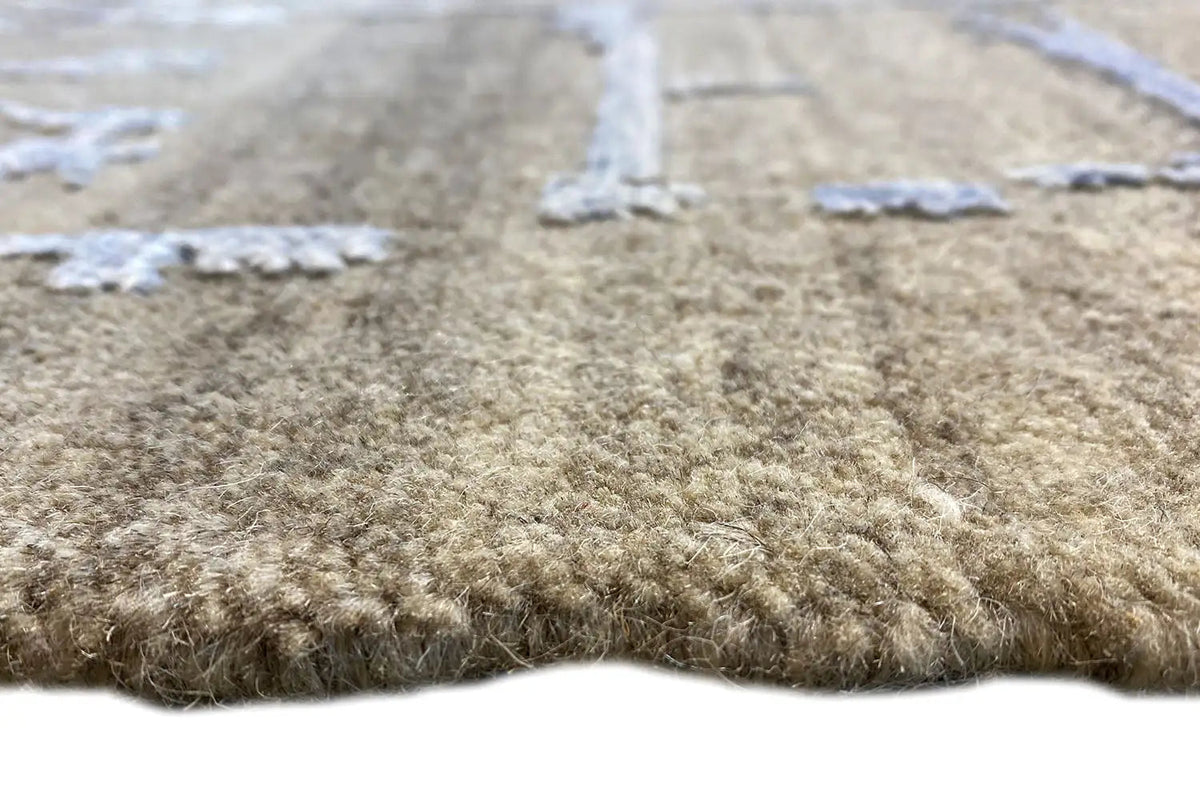 Teppichflor in Graubraun mit abgeriebenen blau-weißen Fäden, Nahansicht