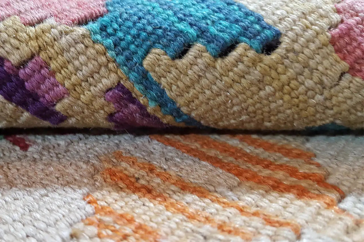 Kelim-Detail: mehrfarbige Faserstruktur mit eingewebten Rauten und Zickzack-Motiven