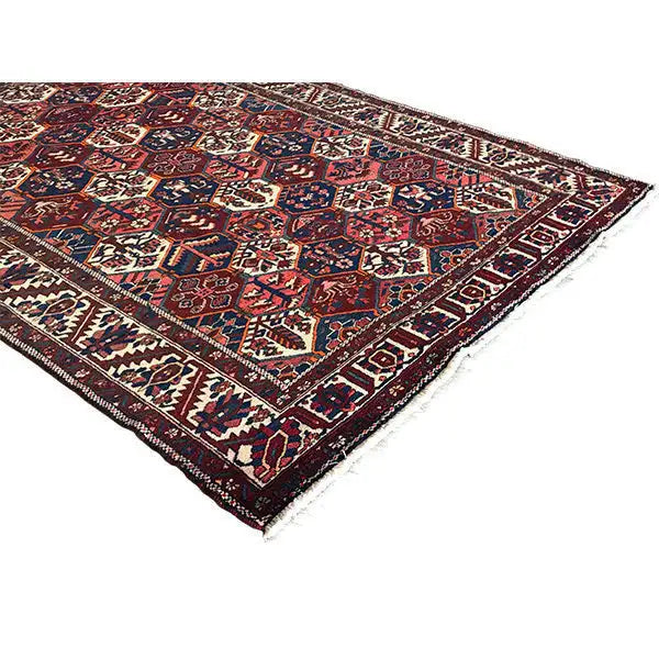 Perserteppich mit Zierbordüre und buntem geometrischem Muster, dunkelrot, blau, creme