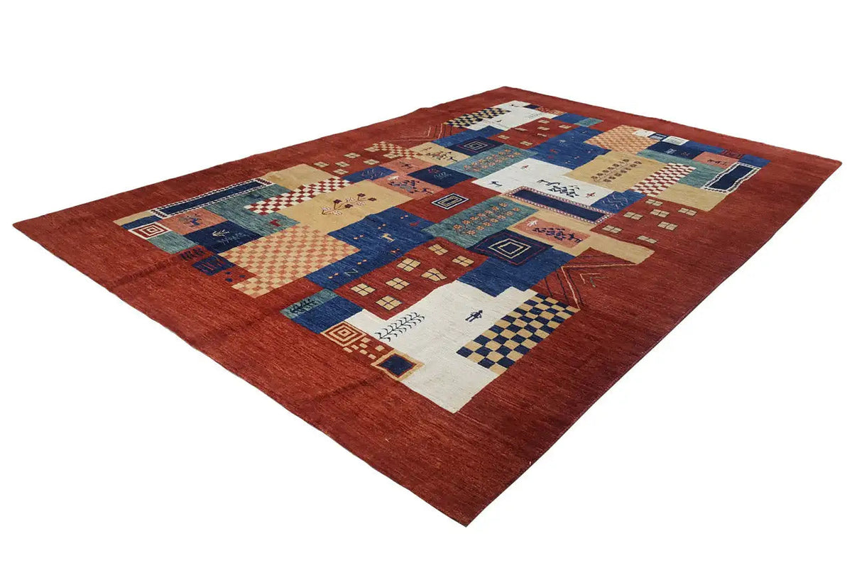 Gabbeh-Lori-Teppich (278x182 cm) im Dreiviertelblick, roter Grund mit Patchwork aus Blau und Creme