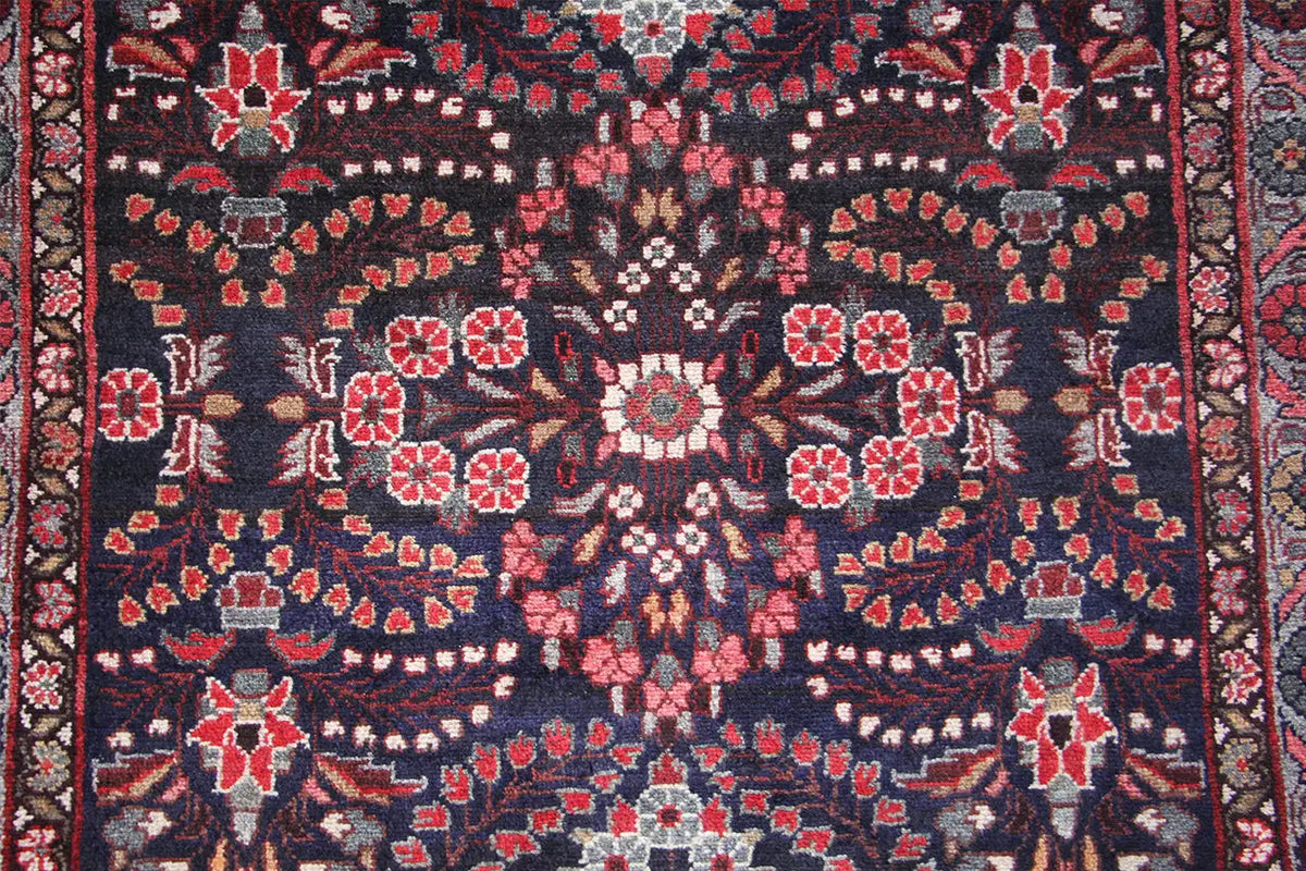 Hamadan-Läufer Nahansicht: blaues Muster mit roten Blüten und weißen Zierelementen