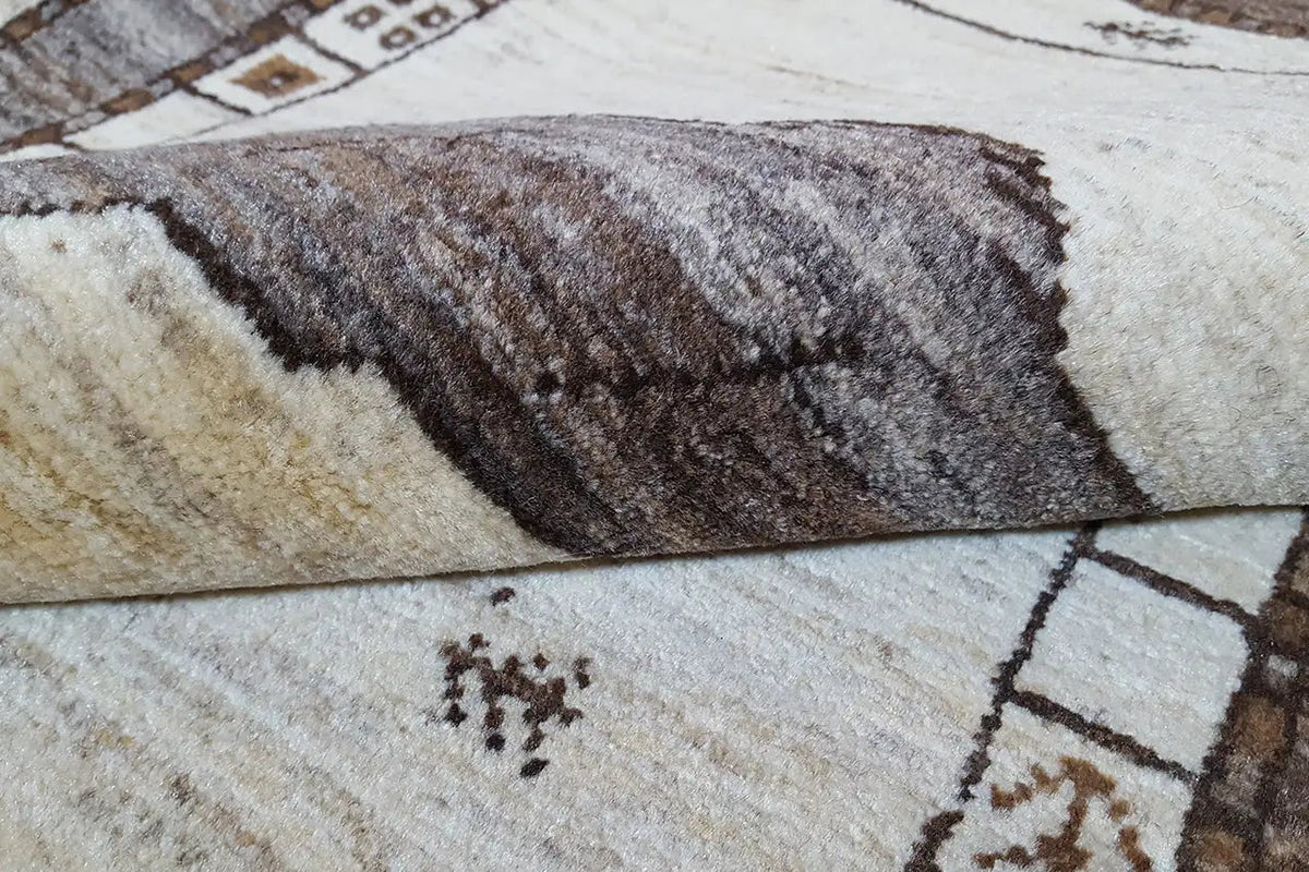 Gabbeh-Teppich im Detail: hochflorige Webstruktur, braunes Muster auf hellem Untergrund