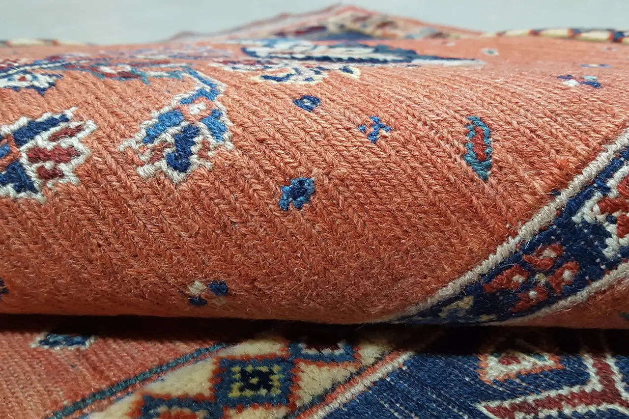 Soumakh-Teppich Detail: orangefarbene Florfläche mit blauem Ziermuster