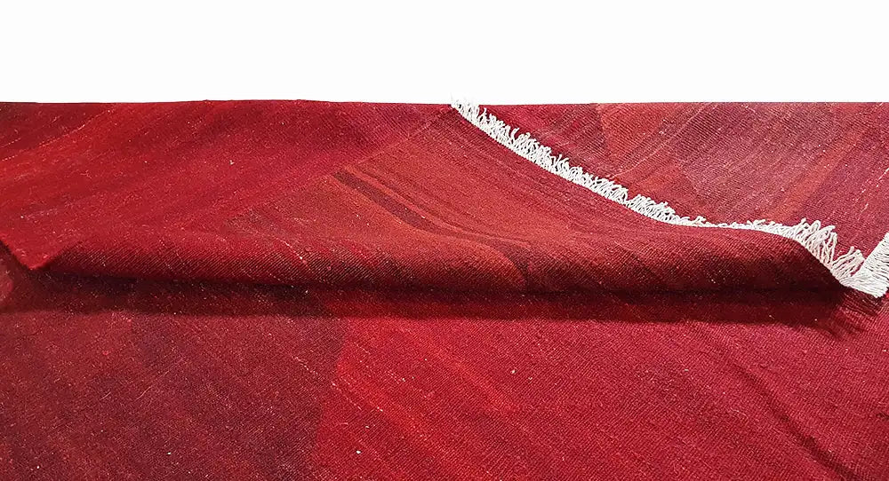 Roter Kilim-Teppich mit feinem, gemustertem Webbild und kurzen weißen Fransen am Rand