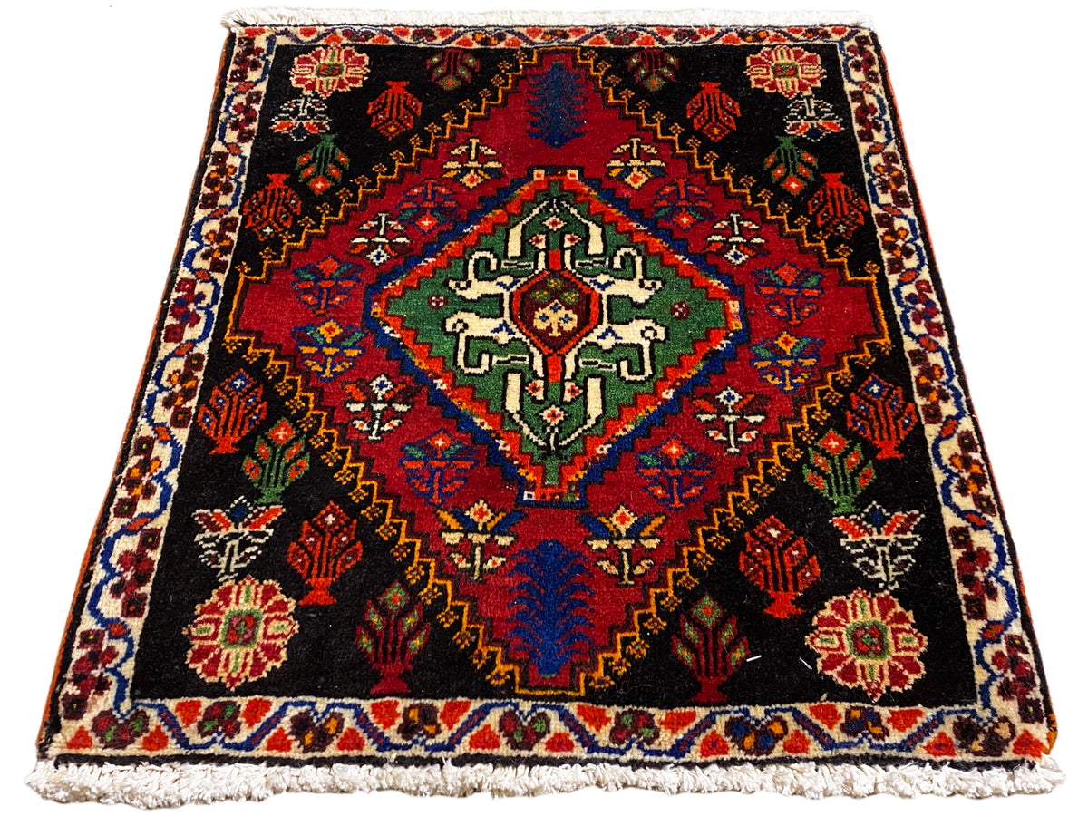 Poshti-Teppich 56x56 cm in Draufsicht, schwarzer Hintergrund mit rotem Randmuster