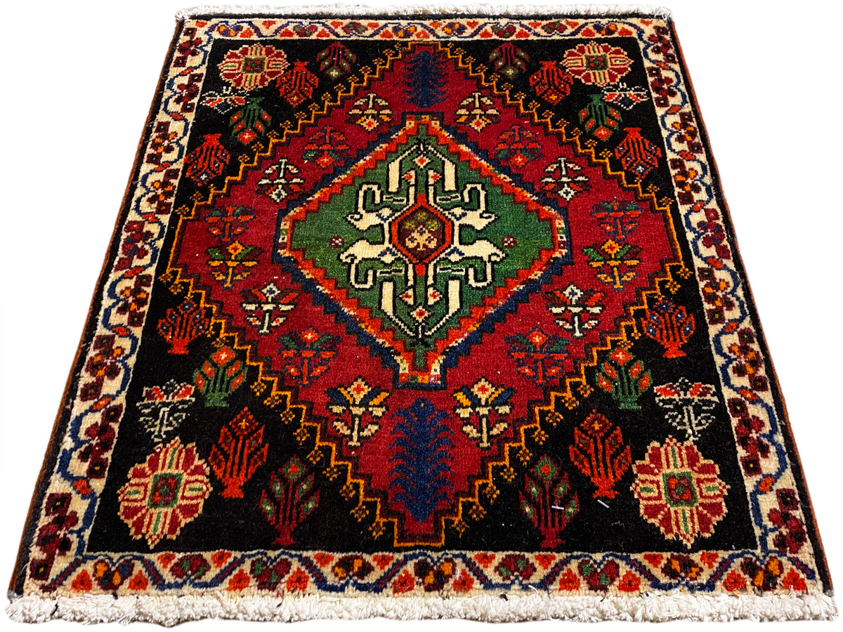 Poshti-Teppich quadratisch, schwarzer Grund mit zentralem Muster in Grün, Rot und Blau