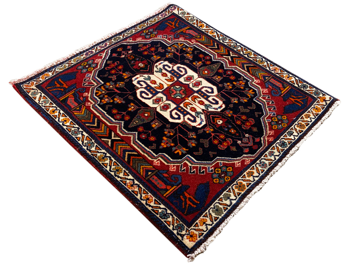 Poshti Teppich im Rauten-Look mit dunklem Grund und weißem Mittelornament