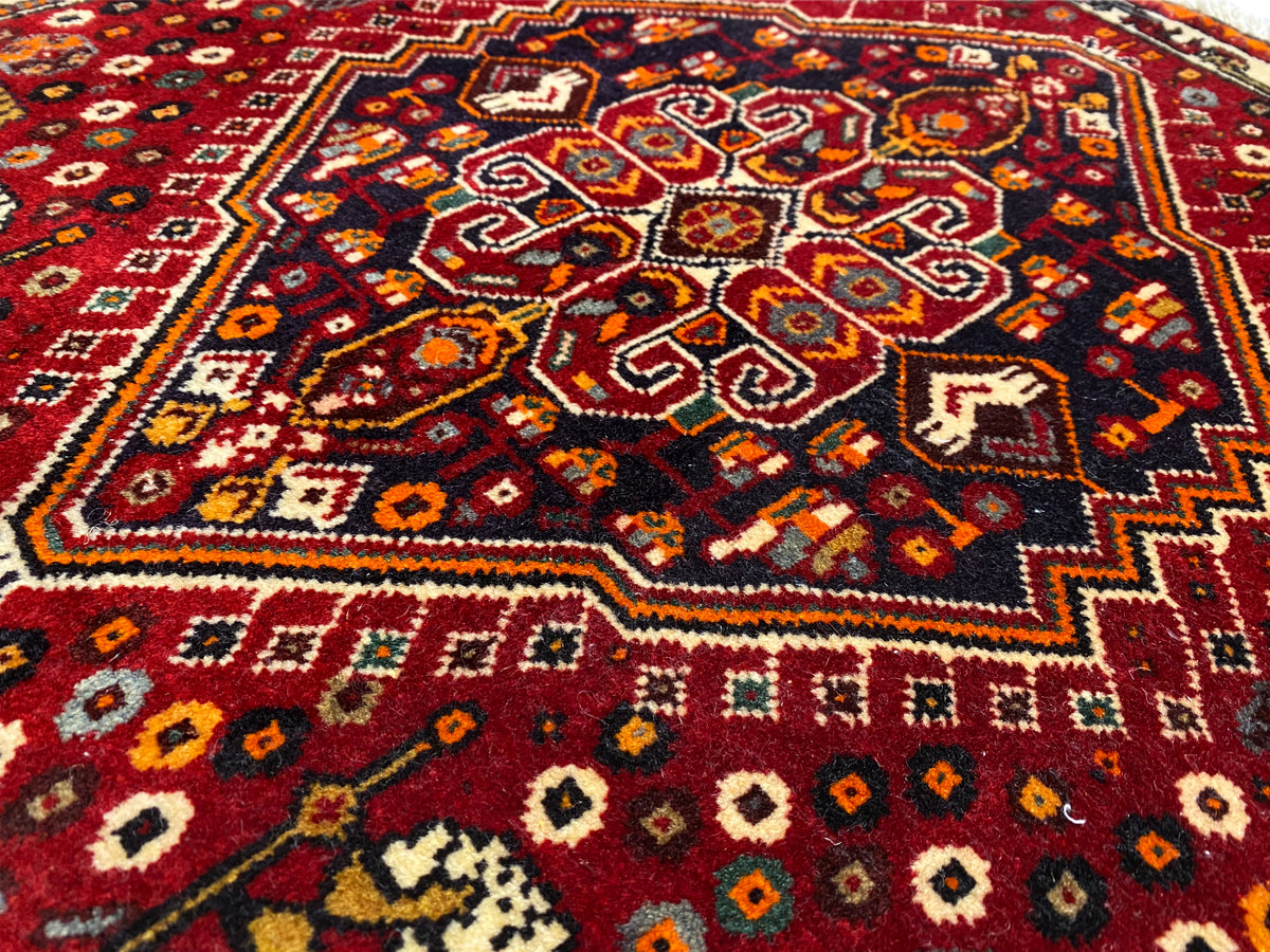 Poshti-Teppich 60x60 cm, Nahansicht des farbigen Zentralornaments auf rotem Grund