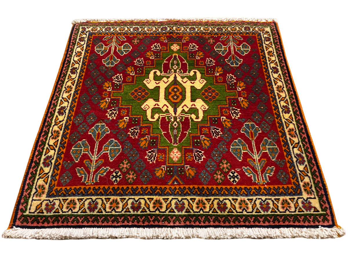 Orientteppich mit rotem Mittelmotiv, grünen Details und beiger Bordüre, mit Fransen
