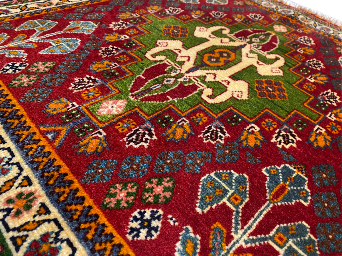 Nahansicht des Orientteppichs: rotes Feld mit floralen Motiven, grünen Akzenten