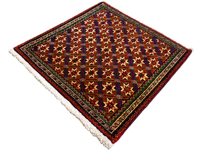 Poshti-Teppich 62x52 cm, Detailansicht: bunte Vierecke und Sterne, dunkler Rand, Fransen.