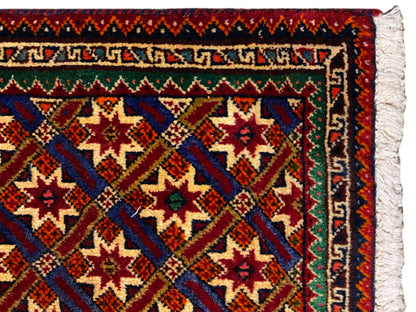 Poshti-Teppich 62x52 cm Nahaufnahme: Bordüre, rote/blau-grüne Muster und weiße Fransen.