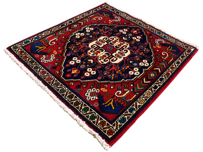 Quadratischer Teppich mit farbigem Ornament, tiefblaue Fläche, Randmotive, Fransen