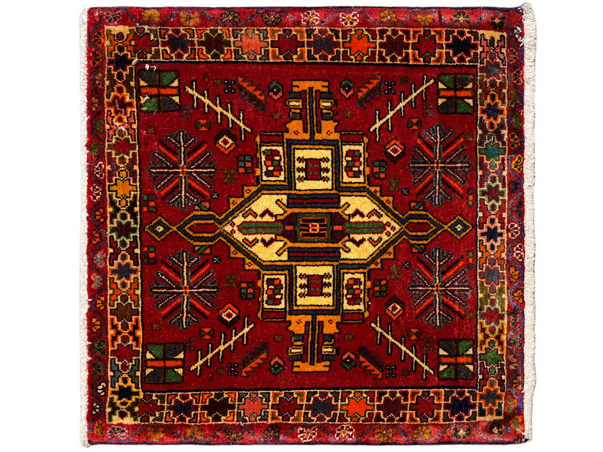 Rechteckiger Poshti Teppich mit rotem Hintergrund und geometrischem Zentralmotiv, mehrfarbig