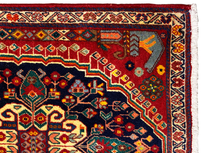 Teppichdetail: farbenfrohes Ornament im dunkelblauen Bereich mit rotem Hintergrund