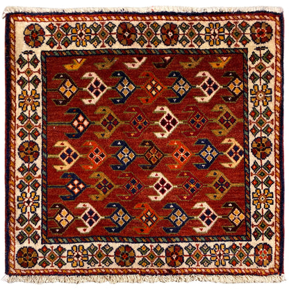Quadratischer Teppich mit rotem Hintergrund, weiß-bunter Bordüre und Fransen