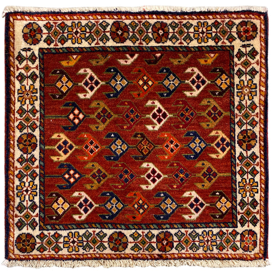 Quadratischer Teppich mit rotem Hintergrund, weiß-bunter Bordüre und Fransen
