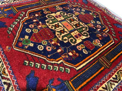 Poshti-Teppich 66x62 cm Detail: rotes Zentralmuster, blaues Feld und bunte Zierlinien.